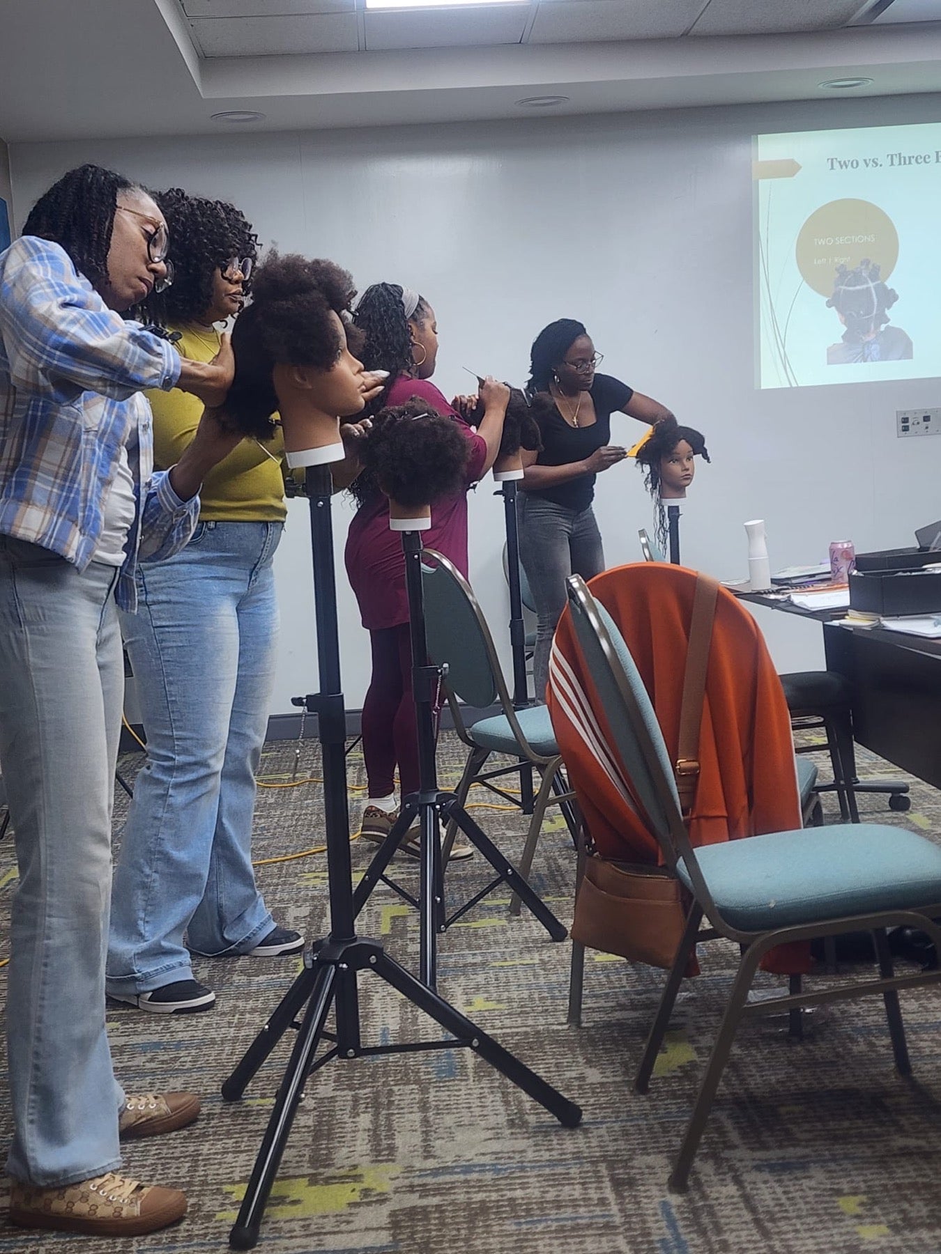 Students practicing Microlocs techniques during a Heal Thy Hair class