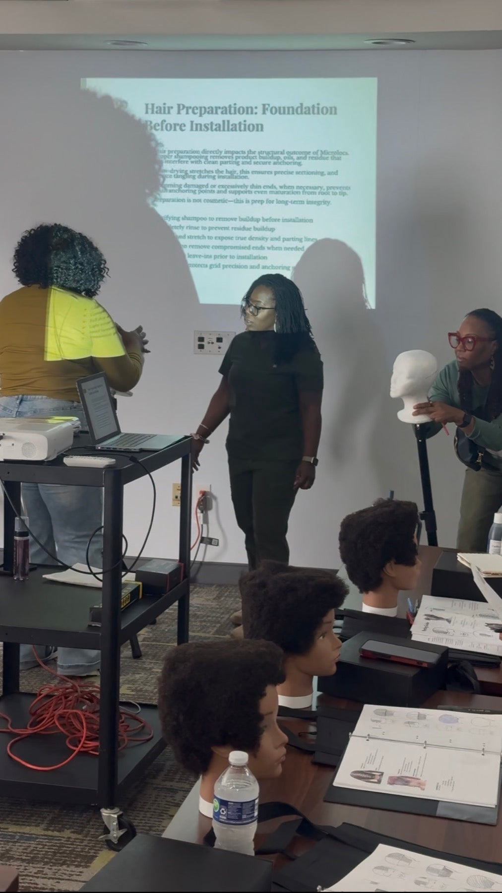 Heal Thy Hair educator guiding students during a Microlocs class